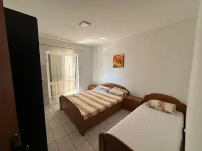 a bedroom with two beds and a window at Pushime te Daka in Ulcinj