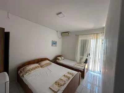 a small bedroom with two beds and a window at Pushime te Daka in Ulcinj