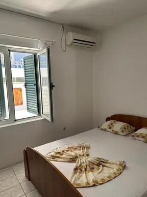 a white bedroom with a bed with a window at Pushime te Daka in Ulcinj