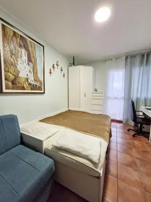 a bedroom with a bed and a blue couch at Ilino Studio Apartment in Bar