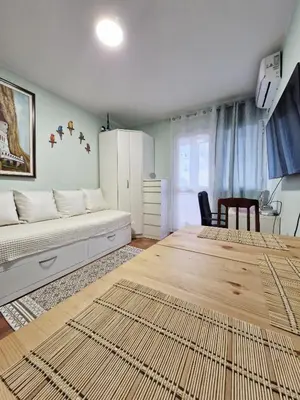 a bedroom with a bed and a table and a chair at Ilino Studio Apartment in Bar