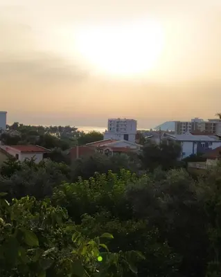 a view of a city with the sunset in the background at Ilino Studio Apartment in Bar