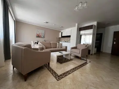a living room with a couch and chairs and a table at Apartment Zevs Bečići in Kravlja