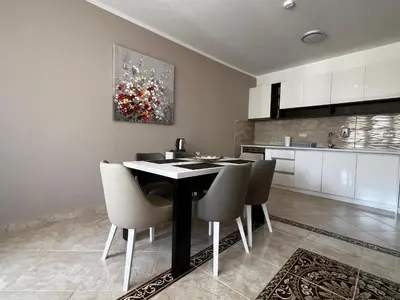 a kitchen and dining room with a table and chairs at Apartment Zevs Bečići in Kravlja