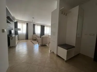 a large living room with a mirror and a chair at Apartment Zevs Bečići in Kravlja