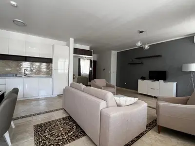 a living room with a couch and a kitchen at Apartment Zevs Bečići in Kravlja