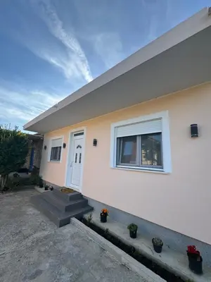a white house with stairs and a window at Lukic Guest house in Ulcinj