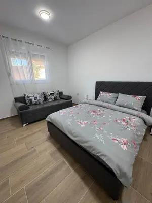 a bedroom with a large bed and a couch at Lukic Guest house in Ulcinj