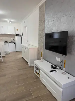 a living room with a large flat screen tv on a wall at Lukic Guest house in Ulcinj