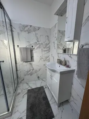 a white bathroom with a sink and a shower at Lukic Guest house in Ulcinj