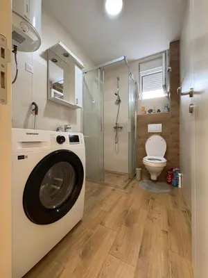 a washing machine in a bathroom with a toilet at Apartments Masa in Podgorica