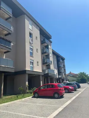 a red car parked in a parking lot next to a building at Apartments Masa in Podgorica