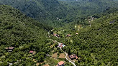 an aerial view of a mountain with houses and trees at Wild silence - Skadar Lake in Virpazar
