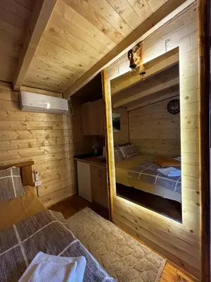 a bedroom with a mirror in a wooden cabin at Brvnara Toma in Cetinje