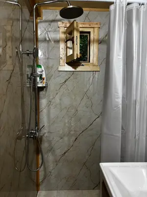 a bathroom with a shower with a sink and a mirror at Brvnara Toma in Cetinje