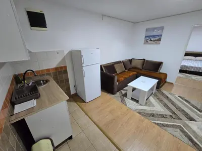 a kitchen and a living room with a couch at Apartman Knez 1 in Podgorica