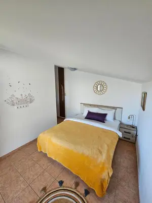 a bedroom with a bed with a yellow blanket on it at Villa Linna in Budva