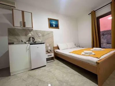 a small bedroom with a bed and a kitchen at RZ apartment in Budva