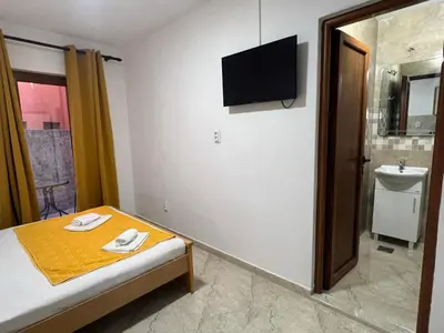 a room with a bed and a television on the wall at RZ apartment in Budva