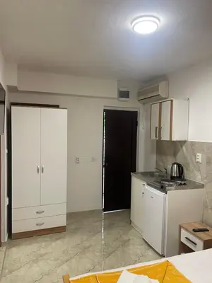 a kitchen with white cabinets and a black door at RZ apartment in Budva