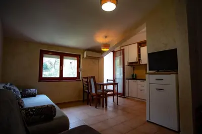 a living room with a couch and a kitchen with a table at студия солнце in Budva