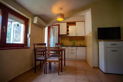 a kitchen with a table and chairs and a television at студия солнце in Budva