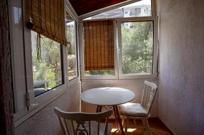 a table and two chairs in a room with windows at студия солнце in Budva