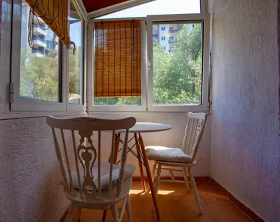 a table and two chairs in a room with windows at студия солнце in Budva