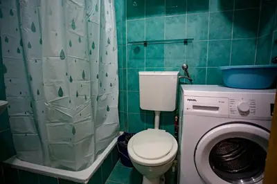 a bathroom with a toilet and a washing machine at студия солнце in Budva