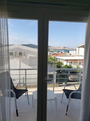 a balcony with a view of the city through the sliding glass doors at Уютная квартира в частном секторе , идеальный отдых у моря in Bar
