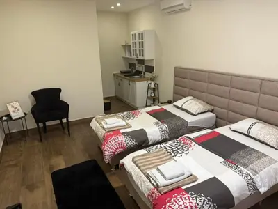 a bedroom with two beds and a desk and a chair at Studio apartament Vukcevic 2 in Golubovci