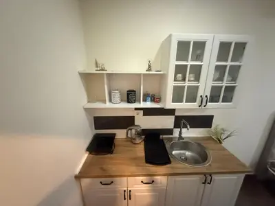 a small kitchen with a sink and white cabinets at Studio apartament Vukcevic 2 in Golubovci
