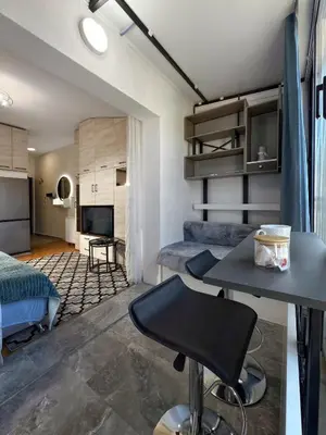 a room with a bed and a table and a bedroom at Studio 89 in Burtaiši