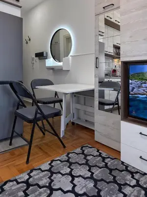 a dining room with a table and a television at Studio 89 in Burtaiši