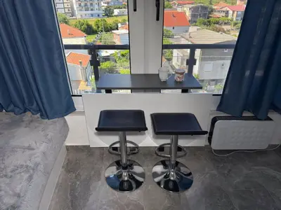 a kitchen with two stools and a counter with a view at Studio 89 in Burtaiši