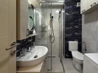 a bathroom with a sink and a toilet and a shower at Studio 89 in Burtaiši