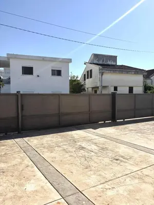a fence in front of a building with a house at Lotus in Donji Štoj