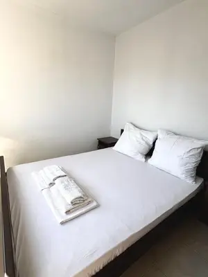 a bed with white sheets and a book on it at Lotus in Donji Štoj