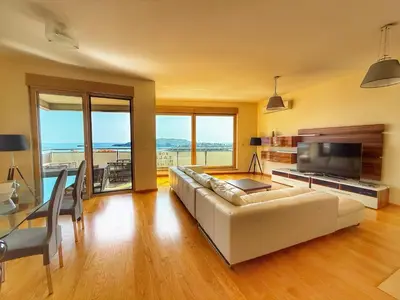 a living room with a white couch and a television at Jelena apart Budva in Becici