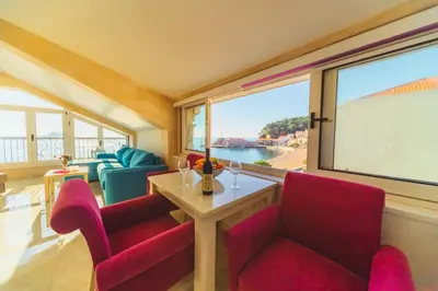 a living room with red chairs and a table and a large window at Galija lux Petrovac in Petrovac na Moru