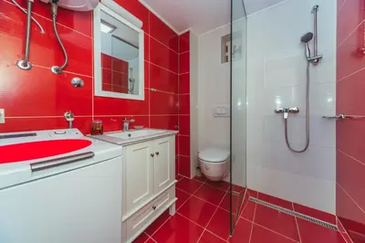 a red bathroom with a sink and a shower at Galija lux Petrovac in Petrovac na Moru
