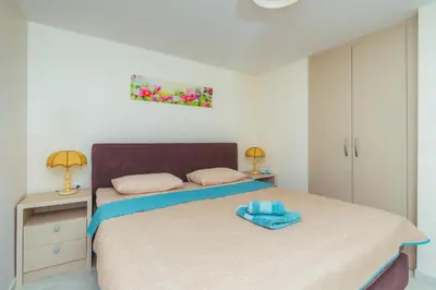 a bedroom with a bed with a blue towel on it at Galija lux Petrovac in Petrovac na Moru