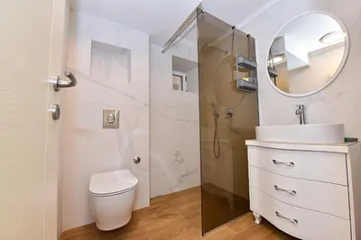 a bathroom with a toilet and a sink and a mirror at Galija lux Petrovac in Petrovac na Moru
