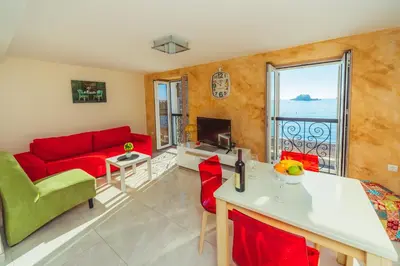 a living room with a red couch and a fireplace at Galija lux Petrovac in Petrovac na Moru