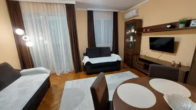a living room with a couch and a table and a television at Apartments Damjan in Budva