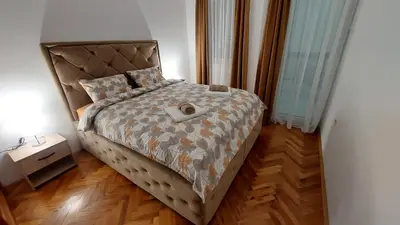 a bedroom with a large bed with a headboard at Apartments Damjan in Budva