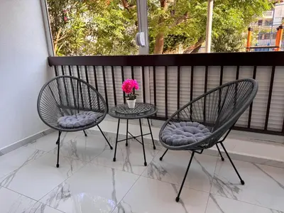 two chairs and a table with a vase of flowers on a porch at Apartments Damjan in Budva