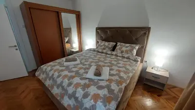 a bedroom with a large bed with a foot board at Apartments Damjan in Budva