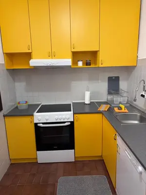 a kitchen with yellow cabinets and a sink at Apartments Damjan in Budva