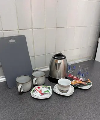 a counter with a coffee pot and plates and cups at Apartments Damjan in Budva